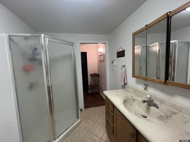 bathroom featuring tile patterned flooring, vanity, and an enclosed shower