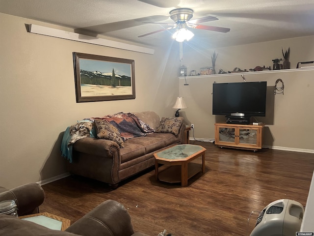 living room featuring ceiling fan, dark hardwood / wood-style flooring, and a textured ceiling