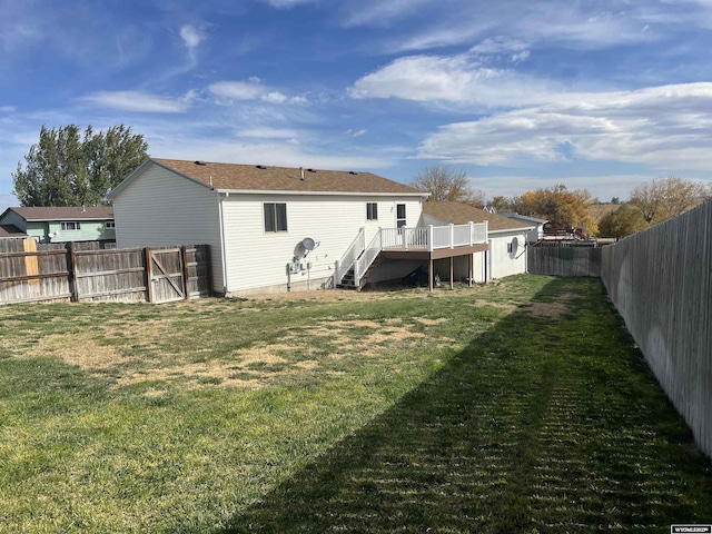 rear view of house with a lawn and a deck