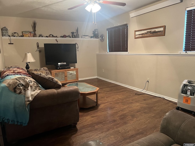 living room with dark wood-type flooring and ceiling fan