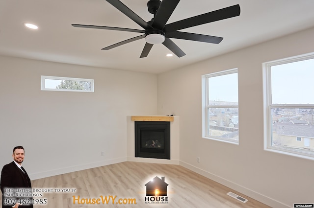 unfurnished living room with recessed lighting, visible vents, baseboards, and a glass covered fireplace