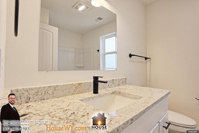 bathroom featuring toilet, visible vents, a shower, and vanity