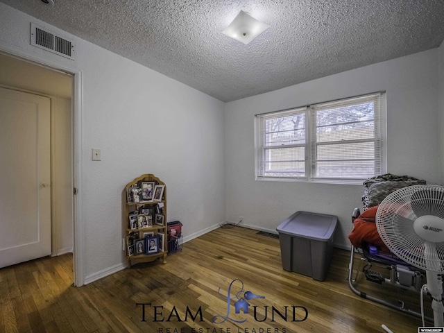 miscellaneous room featuring dark hardwood / wood-style floors and a textured ceiling