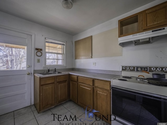 kitchen with light tile patterned flooring, sink, and electric range oven