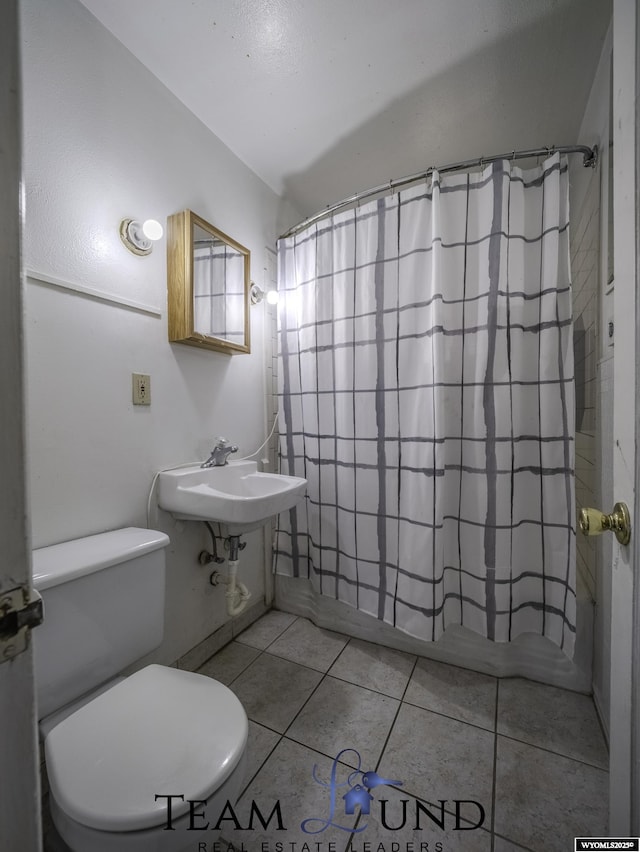 bathroom with sink, tile patterned floors, toilet, and walk in shower