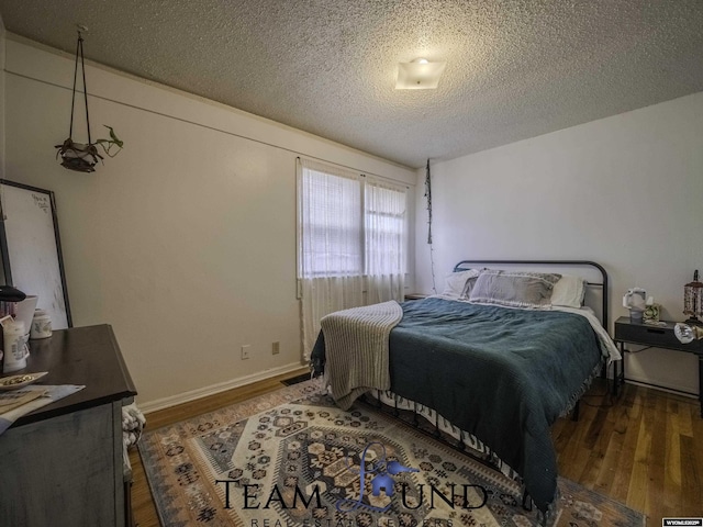 bedroom featuring dark hardwood / wood-style floors and a textured ceiling