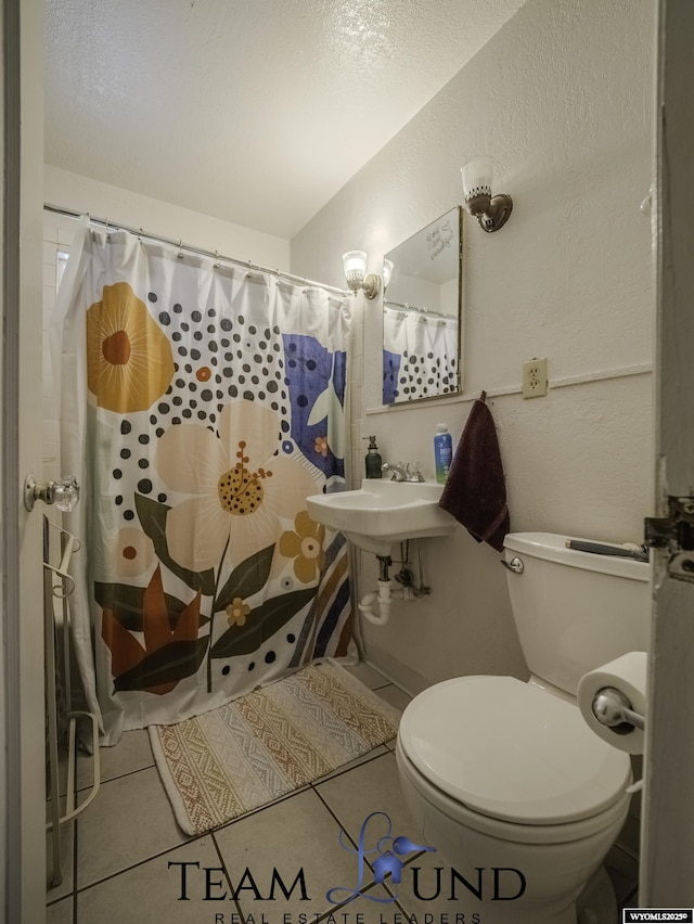 bathroom with curtained shower, tile patterned floors, and toilet