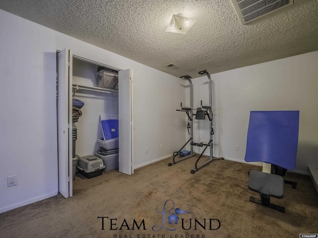 workout room featuring carpet and a textured ceiling