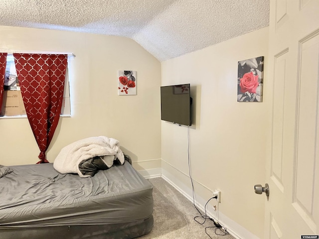 bedroom featuring carpet floors, vaulted ceiling, and a textured ceiling