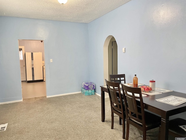 dining space featuring carpet floors and a textured ceiling