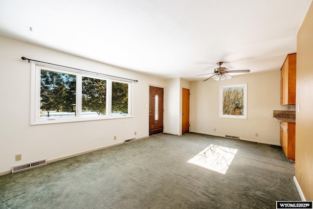 unfurnished living room with ceiling fan and carpet floors