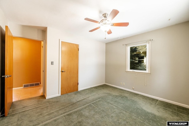 unfurnished bedroom featuring ceiling fan and dark colored carpet