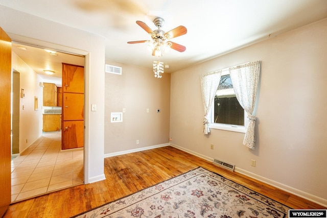 empty room with ceiling fan and light hardwood / wood-style floors