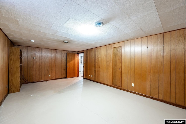 basement featuring wood walls