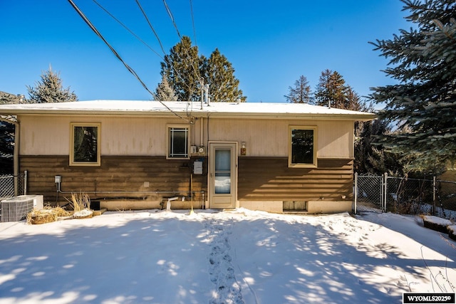 snow covered property with central AC