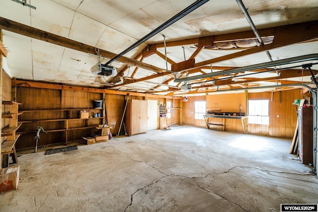 garage with a garage door opener and wooden walls