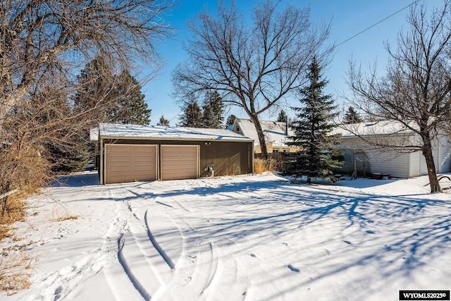 snowy yard with an outbuilding and a garage