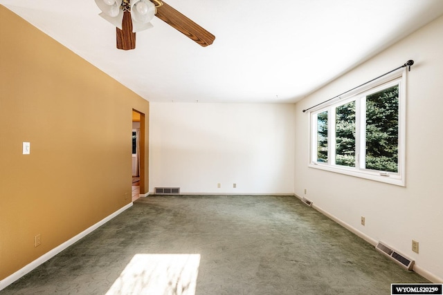 spare room with ceiling fan and dark carpet