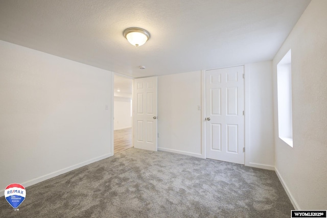 unfurnished bedroom featuring a textured ceiling and carpet flooring