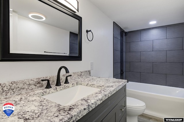 full bathroom featuring vanity, toilet, tiled shower / bath combo, and hardwood / wood-style floors