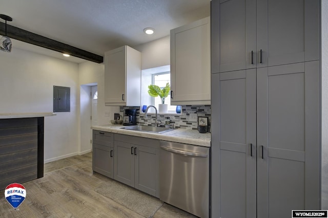 kitchen with sink, decorative backsplash, stainless steel dishwasher, electric panel, and light wood-type flooring