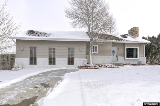 ranch-style home with brick siding and a chimney