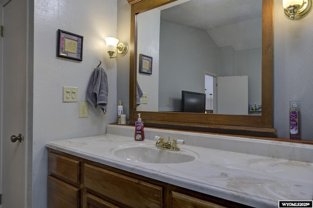 bathroom featuring lofted ceiling and vanity