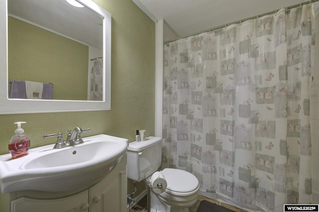 bathroom with toilet, vanity, a shower with shower curtain, and a textured wall