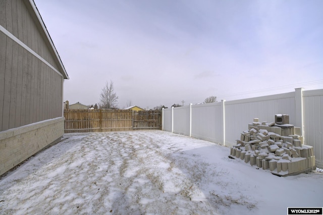 yard layered in snow featuring a fenced backyard