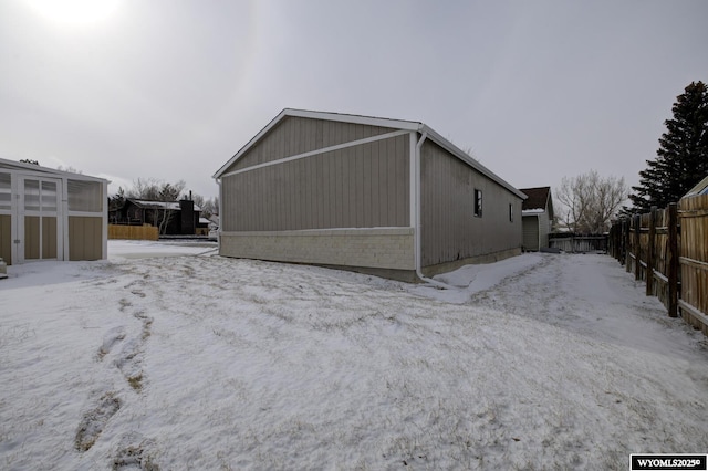 snow covered property with fence