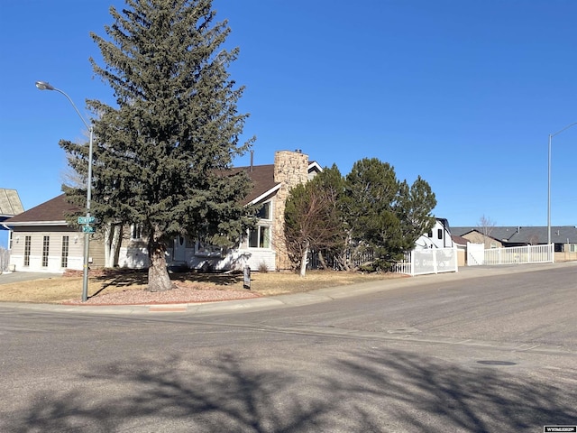 obstructed view of property featuring a residential view, a gate, fence, and a chimney