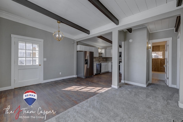 unfurnished living room with vaulted ceiling with beams, a notable chandelier, plenty of natural light, and dark hardwood / wood-style floors