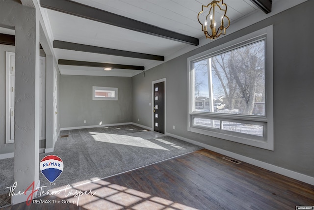 entrance foyer featuring beamed ceiling, dark wood-type flooring, and a notable chandelier