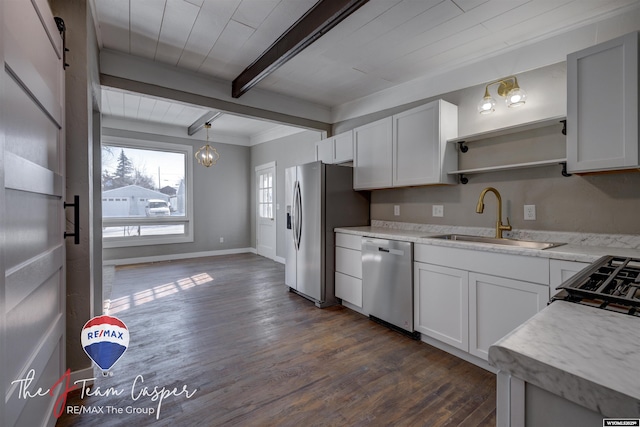 kitchen with pendant lighting, appliances with stainless steel finishes, sink, and white cabinets