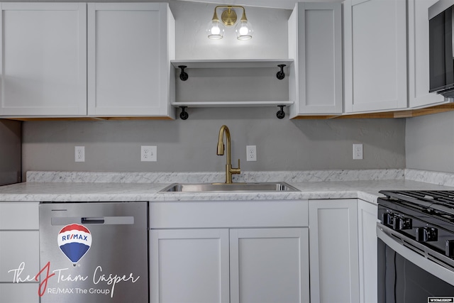 kitchen with sink, range with gas cooktop, stainless steel dishwasher, and white cabinets