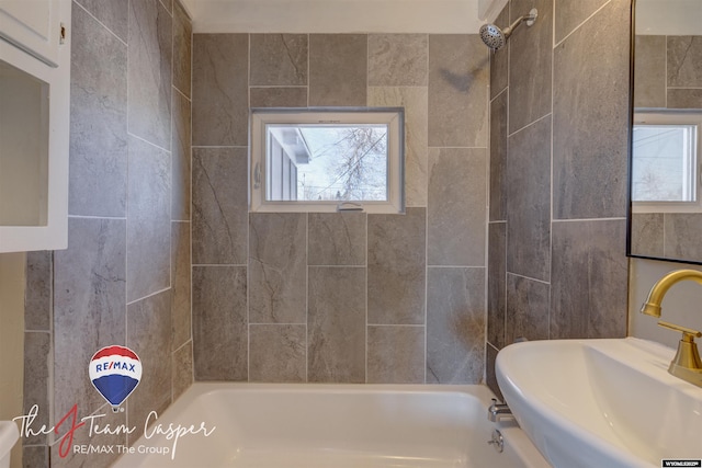 bathroom featuring sink, tiled shower / bath combo, and plenty of natural light