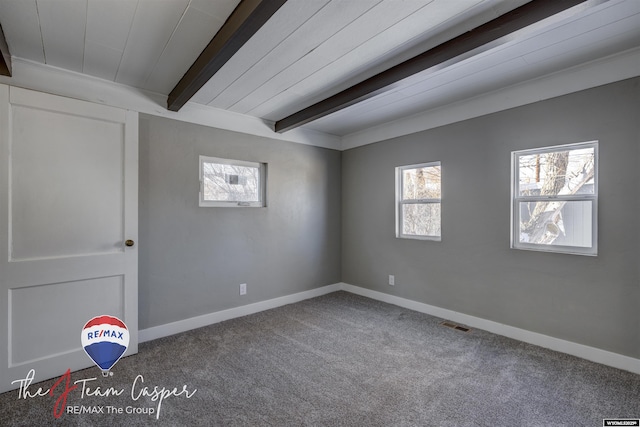 carpeted empty room with beamed ceiling