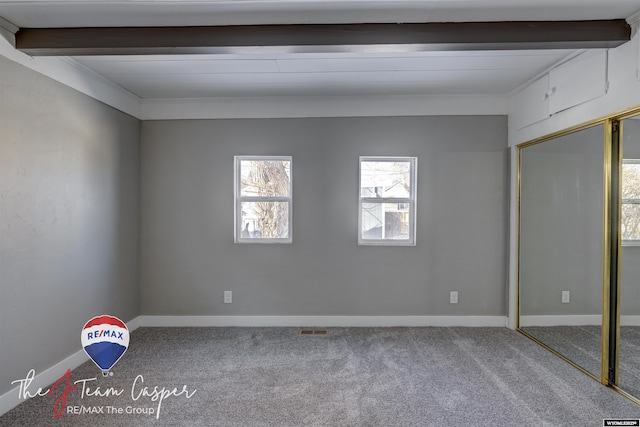 unfurnished room featuring carpet floors and beam ceiling