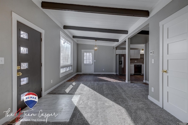 foyer featuring beamed ceiling and dark colored carpet