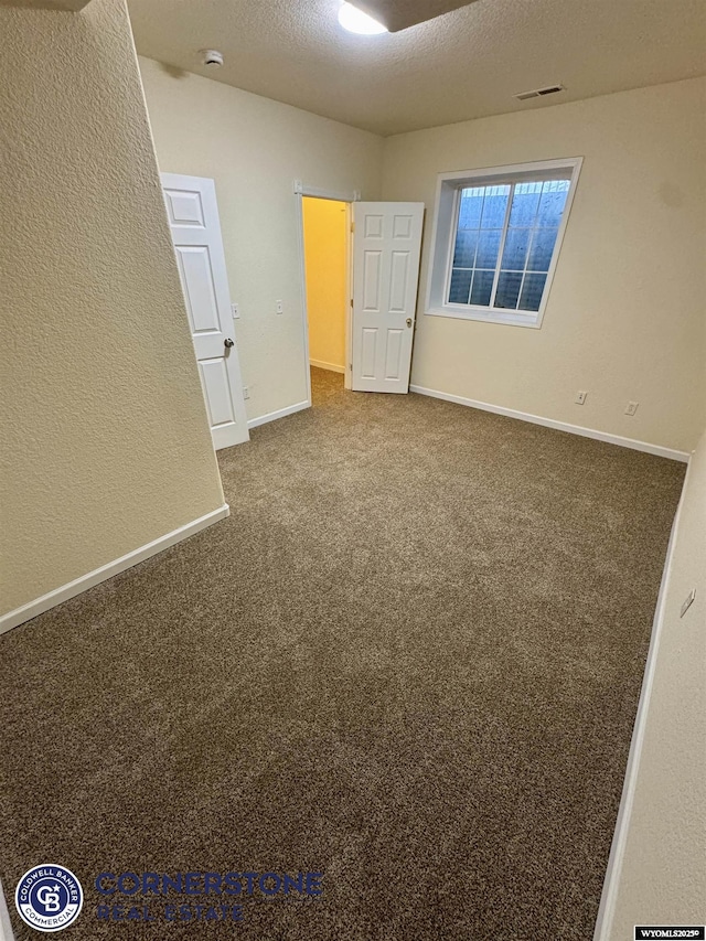 spare room with carpet floors and a textured ceiling