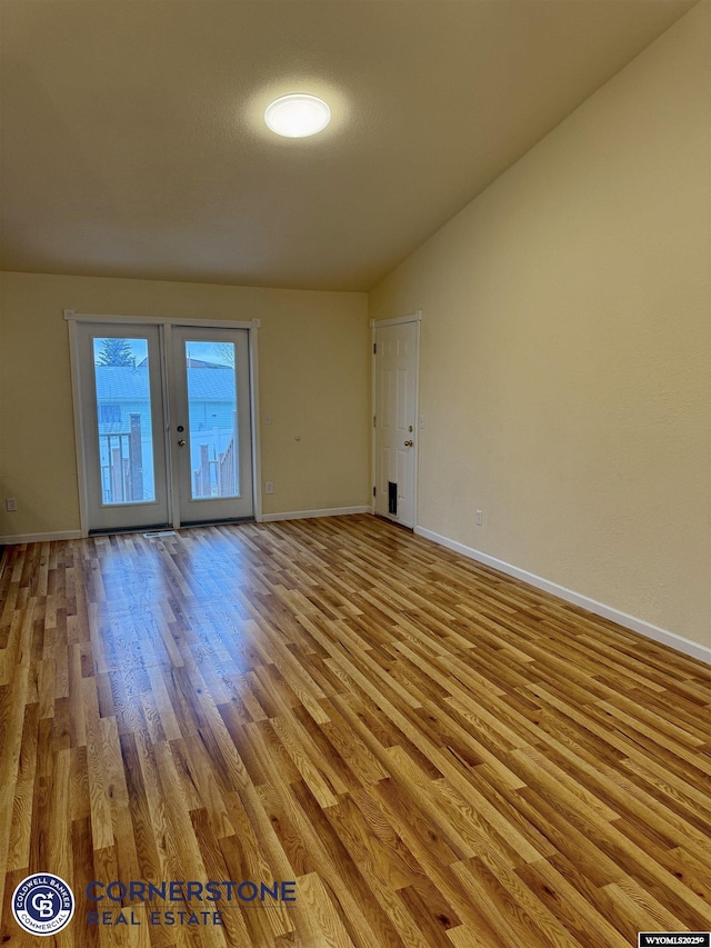 spare room featuring vaulted ceiling and light wood-type flooring