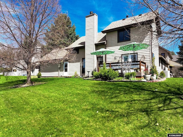3911 Spyglass Cir, Riverton, WY 82501 - back of property featuring roof with shingles, a chimney, a lawn, and central AC
