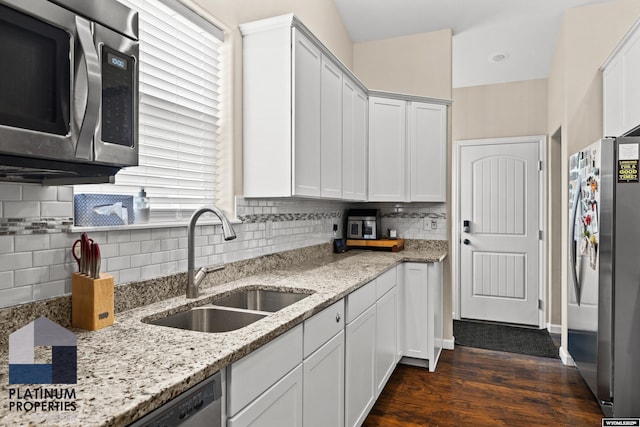 kitchen featuring sink, appliances with stainless steel finishes, white cabinetry, dark hardwood / wood-style floors, and light stone countertops