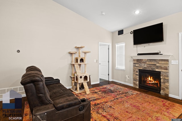 living room with a fireplace, dark wood-type flooring, and vaulted ceiling