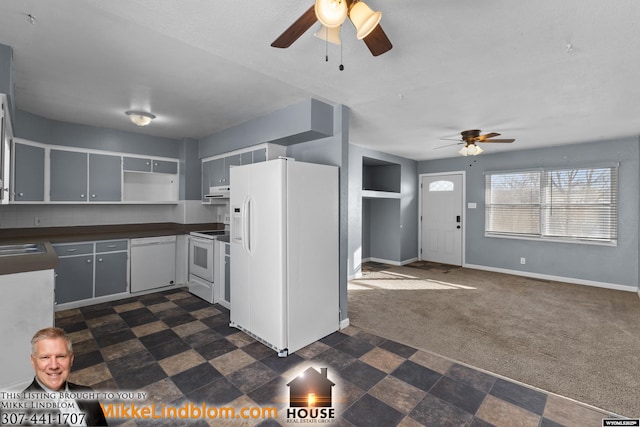 kitchen featuring dark carpet, sink, and white appliances