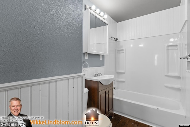 full bathroom with vanity, tub / shower combination, hardwood / wood-style floors, and toilet