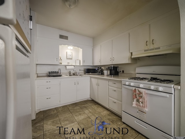 kitchen featuring sink, white range with gas stovetop, and white cabinets