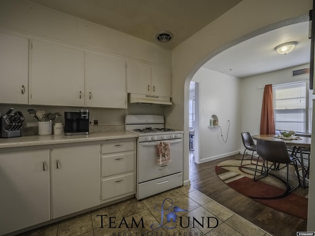 kitchen featuring white cabinets, white range with gas stovetop, and light wood-type flooring