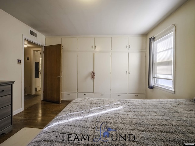 bedroom with dark hardwood / wood-style floors