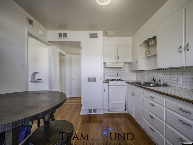 kitchen with sink, white cabinetry, dark hardwood / wood-style floors, white gas range, and decorative backsplash